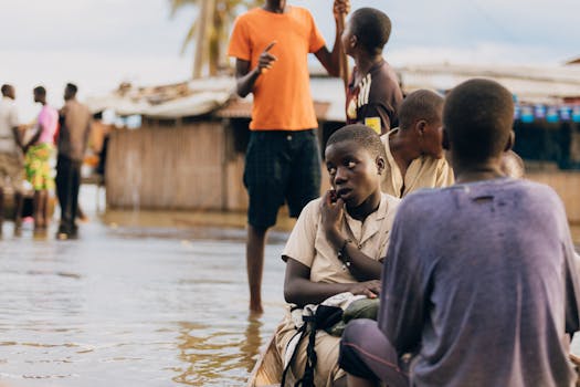 Children in rural village navigate flood waters, depicting resilience.