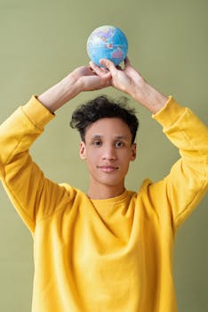 Confident youth holds a small globe, embodying global awareness and future aspirations.