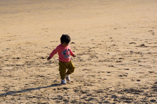 Cute toddler enjoying a playful day on the sandy beach in Odisha, India.