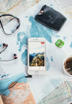 Flat lay of smartphone, map, and travel accessories, inspiring wanderlust.