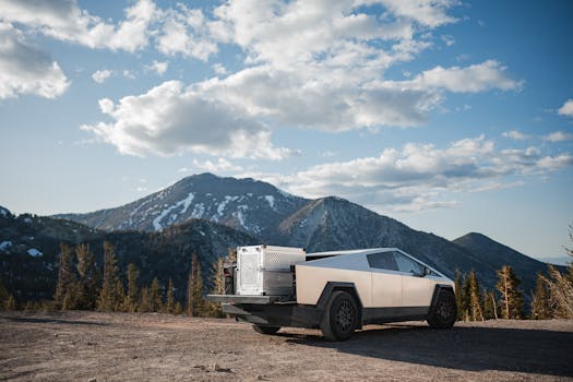 Tesla Cybertruck parked on mountain overlook against a breathtaking landscape. Perfect blend of technology and nature.