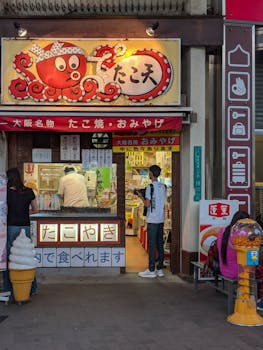 A vibrant scene at a Takoyaki shop in Osaka, Japan, featuring colorful signage and urban life.