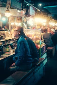 Atmospheric capture of a bustling night market in Seoul with people enjoying Korean street food.