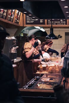 Bakers preparing trdelník pastries at a Prague market stall, showcasing traditional Czech cuisine.