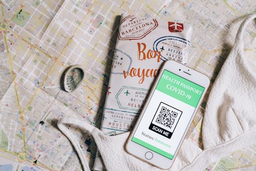 Smartphone displaying a health passport with QR code on a travel map and passport cover.